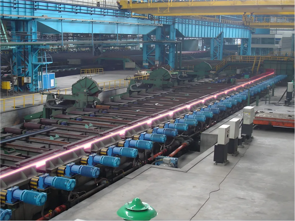 A long row of LiuDrive heavy-duty gearmotors driving a roller table in a high-temperature steel rolling mill. Engineered for high torque and demanding industrial environments, we provide robust 1:1 replacement drives for continuous steel processing and metallurgy machinery.